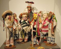 a group of figurines that are standing on a shelf in front of a wall