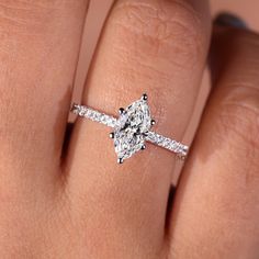 a woman's hand with a diamond ring on top of her finger and an engagement band