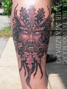 a man's leg with a tattoo on it that has an image of a demon