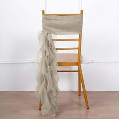 a chair with a ruffled cloth draped over it's back in front of a white wall