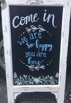 a chalkboard sign that says come in we are so happy you are here