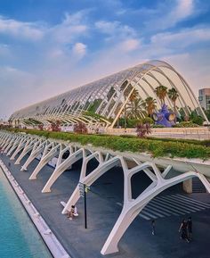 the walkway is lined with green plants and white arches