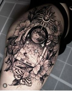 a woman's thigh with tattoos and flowers on it