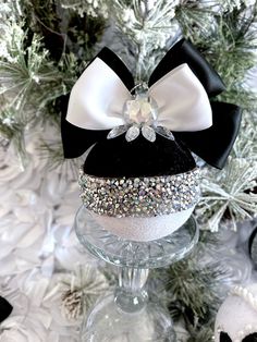 a black and white bow headband on top of a wine glass in front of a christmas tree