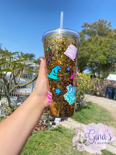 a person holding up a cup with stickers on it