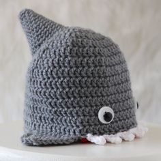 a crocheted gray hat with an eye on it