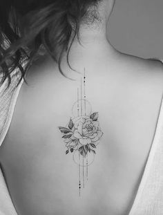 a woman's back with a rose tattoo on her left shoulder and an arrow in the middle