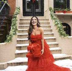 a woman in a red dress standing on steps