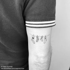 a man's arm with stockings hanging from the clothes line tattoo on his left forearm