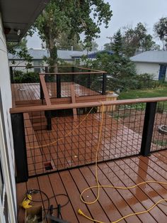 a wooden deck with metal railings and an electric device on it's side