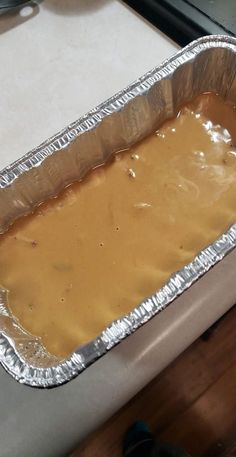 an uncooked baking pan with peanut butter on it sitting on a counter top