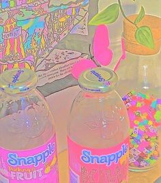 two water bottles sitting on top of a table next to sprinkles and candy