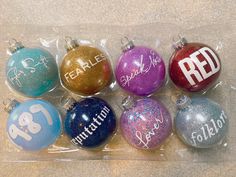 six christmas ornaments with the names of different people on them in plastic bags, sitting on a table