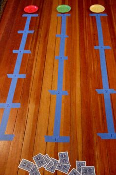 a wooden floor with several pieces of paper cut out to look like train tracks on it