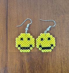 a pair of yellow and black beaded earrings with an emo pacman face