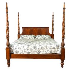 a wooden bed with four posts and a floral comforter on it's side