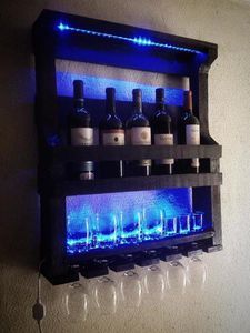 a shelf with wine glasses and bottles on it