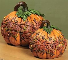 two decorative pumpkins sitting on top of a wooden table