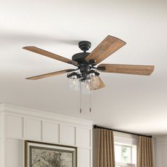 a ceiling fan with three wooden blades in a living room