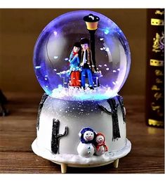 a snow globe with two people sitting on it