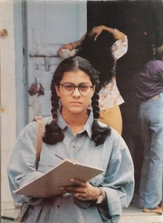 an old photo of a woman with glasses and braids holding a book in her hands