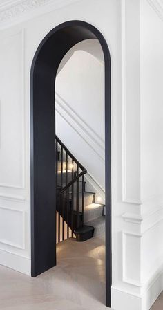 an open doorway leading to a staircase in a house with white walls and wood floors