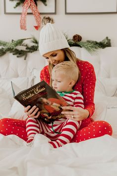 a woman reading a book to a child on the bed with christmas decorations in the background