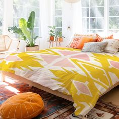 a bed with yellow and pink comforter in a bedroom