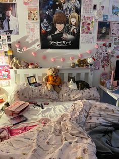 an unmade bed in a dorm room with posters on the wall and stuffed animals