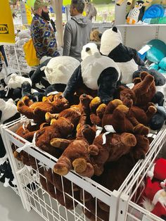 several stuffed animals are piled on top of each other in a basket at a store