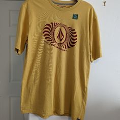 Volcom Youth Boys Size Xl Short Sleeve Crewneck Tee. Mustard Color Nwot. Approximately Measurements Pit To Pit: 18" Length: 27" Sleeve: 9" H34 Mustard Graphic Print Cotton T-shirt, Mustard Cotton T-shirt With Graphic Print, Yellow Cotton Tops With Graphic Print, Yellow Cotton Top With Graphic Print, Mustard Casual Top With Graphic Print, Casual Mustard Top With Graphic Print, Retro Mustard Cotton Top, Retro Yellow Shirt With Screen Print, Retro Yellow Tops With Screen Print