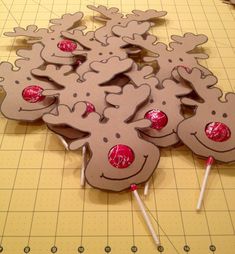 a group of reindeer cut out on top of a cutting board with candy canes