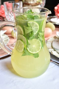 a pitcher filled with lemonade and lime slices