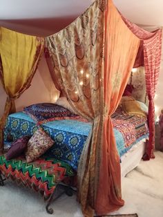 the canopy bed is made up with colorful fabrics and lights on it's headboard