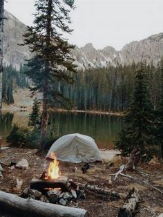 a tent is set up next to a campfire