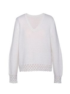 a white sweater with an openwork design on the shoulders and sleeves, in front of a