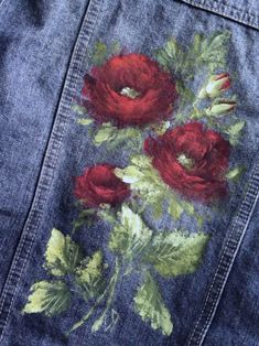 an embroidered denim jacket with red roses on it