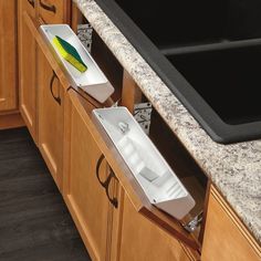 two white boxes sitting on the side of a counter next to a black dishwasher