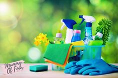 cleaning supplies and gloves sitting on top of a wooden table in front of green boket