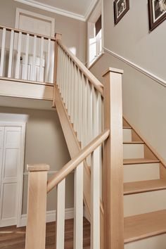 there is a staircase with white railings and wood handrails in the house