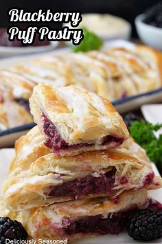 blackberry puff pastry stacked on top of each other with fresh blackberries in the background