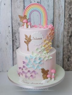 a three tiered cake with a rainbow on top