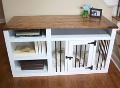 a dog kennel with two dogs in it and some books on the top shelf