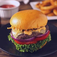 a cheeseburger on a black plate with fries