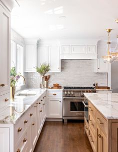 a kitchen with white cabinets and marble counter tops is featured in the instagram page