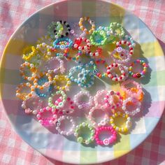 a white plate topped with lots of colorful beads