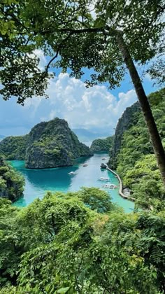 an island with many small boats in the water surrounded by greenery and blue sky