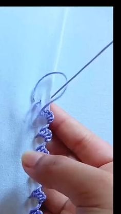 someone is stitching something on the side of a piece of fabric with a crochet hook