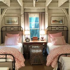 two beds in a bedroom with pink and white bedding