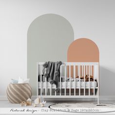 a baby's room with a white crib and an orange circle on the wall